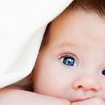 A baby under a hypoallergenic blanket